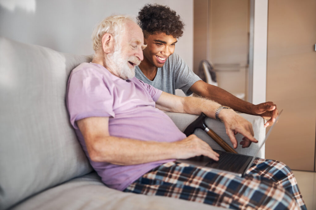 Pensioner and his caregiver looking at the computer