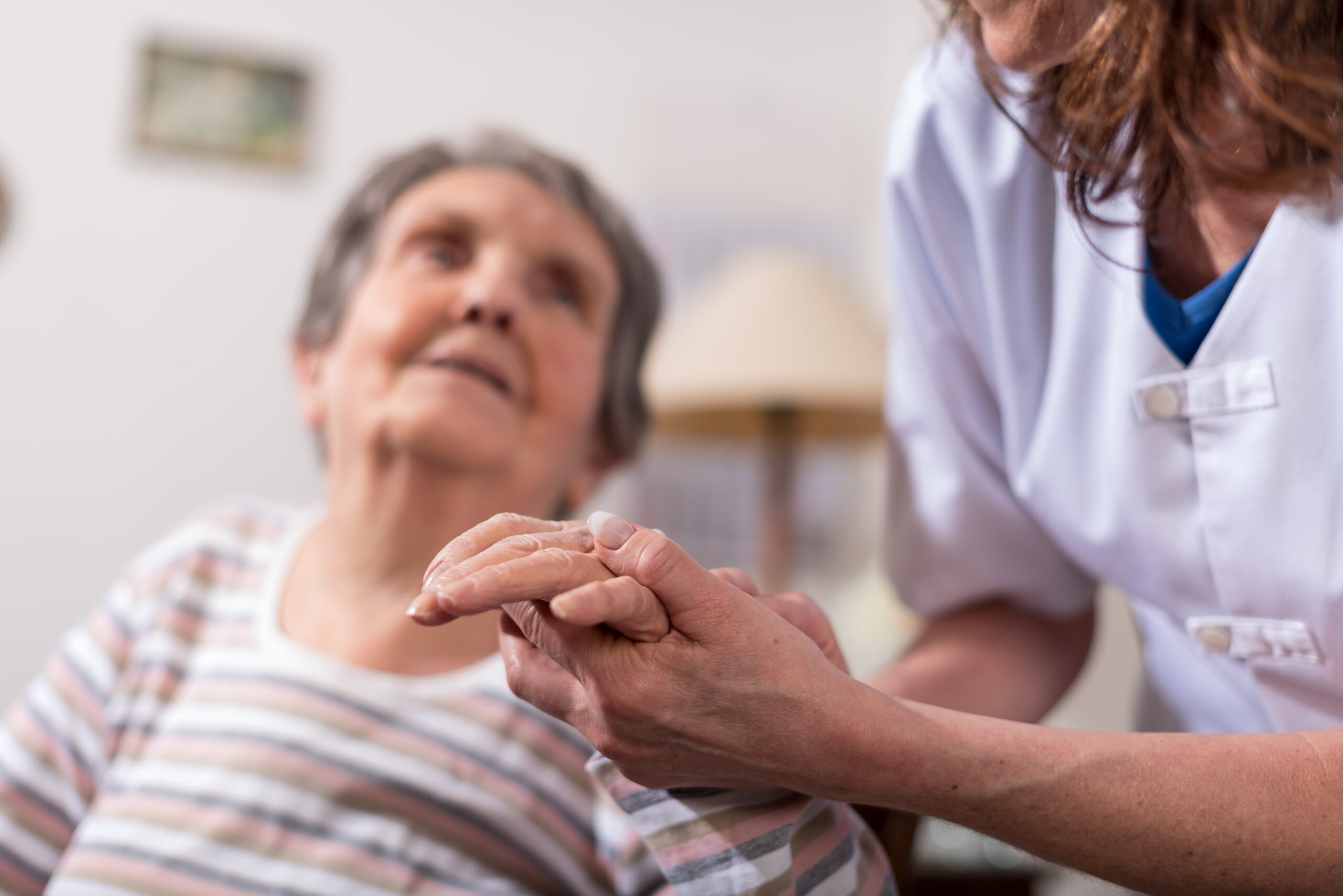 Nurse holding the hand of an old woman